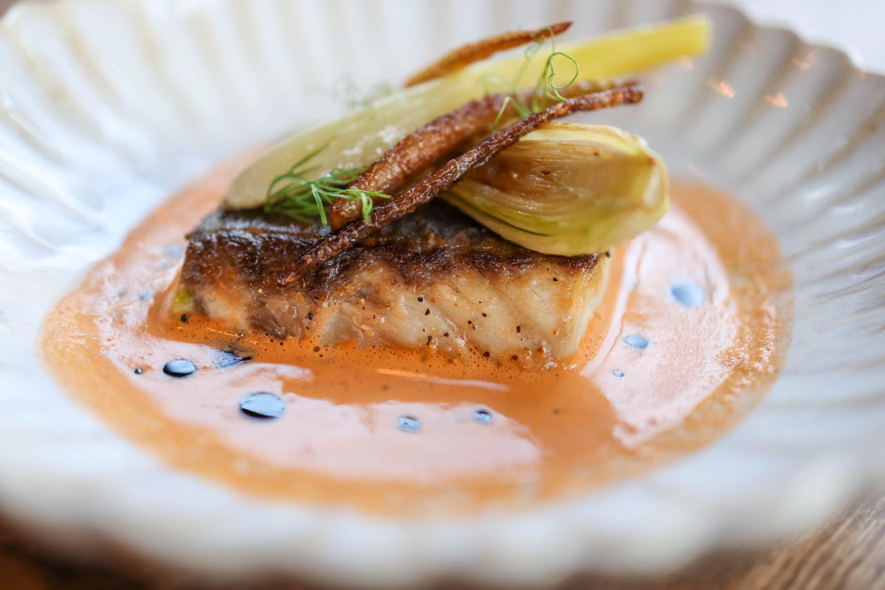 project-02-c Delightful gourmet dish featuring grilled fish with vegetables and a savory sauce.